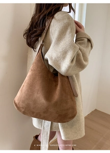 Side view of retro brown suede tote bag styled with a beige coat for autumn vibes