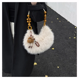 Detail of cream plush hobo bag with wooden bead handle and a small bear pendant