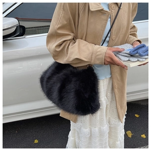 Detail of a fluffy black faux fur crossbody bag with soft plush texture for autumn