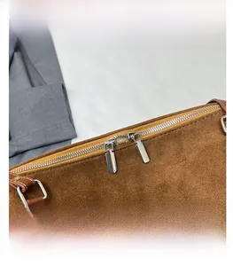 Close-up of vintage brown faux suede tote bag featuring dual silver zipper hardware