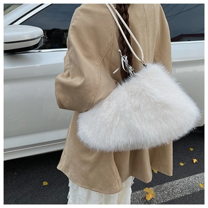 Close-up of fluffy white faux fur shoulder bag with soft texture and slim shoulder strap