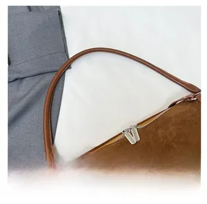 Detailed top view of brown suede tote bag featuring silver metal double zippers and leather straps