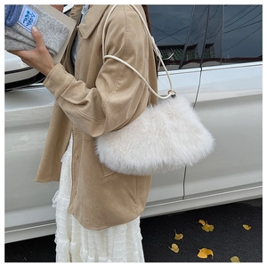 Detail of white fluffy plush shoulder bag with faux fur texture and round handle straps