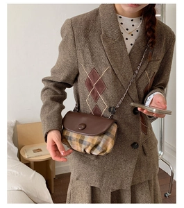 Retro plaid saddle bag with brown leather flap and sleek metal chain strap on model