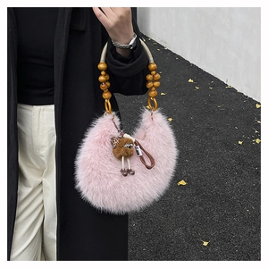 Detailed close-up of a pink fuzzy handbag featuring a round wooden bead handle