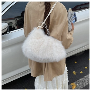 Detail of white plush shoulder bag with fluffy faux fur and elegant ribbon bow decoration