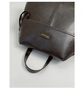 Detailed macro view of retro brown leather handle with golden Aimeier logo and fine stitching