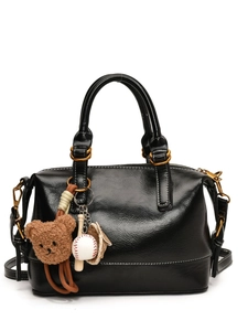 Retro black glossy tote bag with crossbody strap and cute plush bear charm accents
