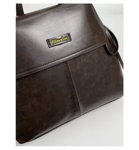 Detail of dark brown vintage faux leather backpack featuring the yellow Aimover logo patch