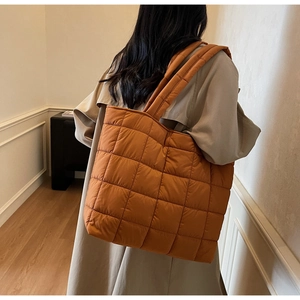 Close-up of caramel quilted tote bag with large diamond stitching and padded texture