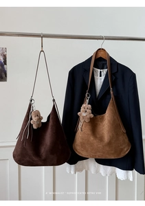Detailed view of large Hobo tote bags in coffee and caramel suede with teddy bear charm
