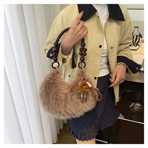 Detail of camel faux fur handbag with wooden bead handle and cute charm accessory