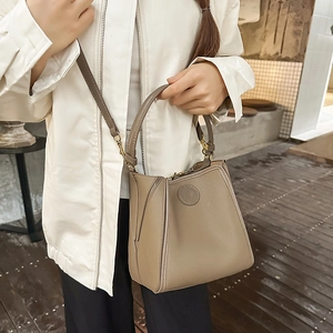 Detail of khaki bucket bag with lychee pattern leather and adjustable shoulder strap