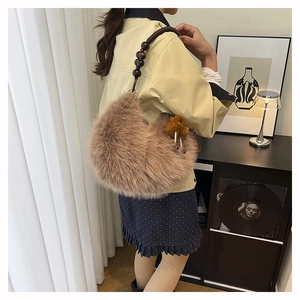 Fuzzy shoulder bag with dark wooden bead handle and plush texture in home setting