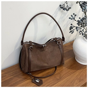 Detail of dark brown suede shoulder bag with dual zippers and silver padlock decoration