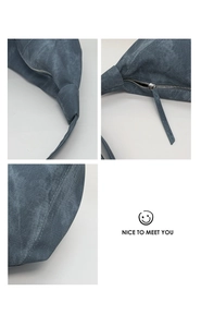 Detail showing the shoulder strap knot, zipper closure and stitching on blue grey canvas bag