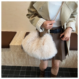 Close-up of fluffy faux fur handbag paired with a beige coat in a stylish indoor setting