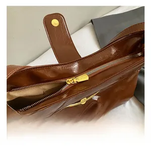 Détail du sac cabas vintage marron avec fermeture éclair dorée et fermoir magnétique