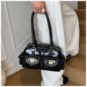 Detail of vintage black faux leather shoulder bag with golden hardware and flap pockets