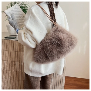 Detail of fluffy brown plush shoulder bag with smooth leather strap on model