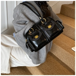 Detail view of retro black leather shoulder bag with white contrast stitching and gold locks