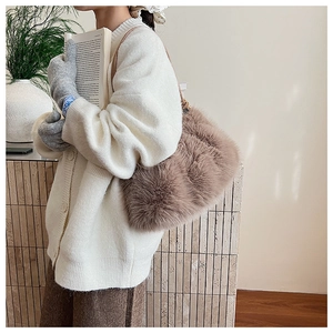 Close-up of fluffy light coffee shoulder bag showing soft fur texture in a warm setting