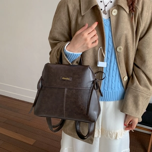 Detailed view of deep brown vintage backpack in matte PU leather with Aimador logo plate