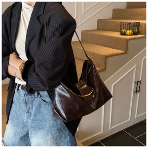 Détail du sac hobo marron foncé avec texture huilée brillante et boucle métallique chic