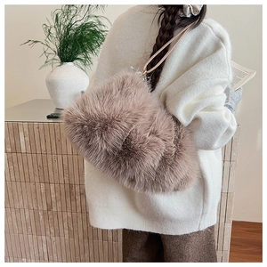 Detail of plush latte brown faux fur shoulder bag with leather strap worn by a model