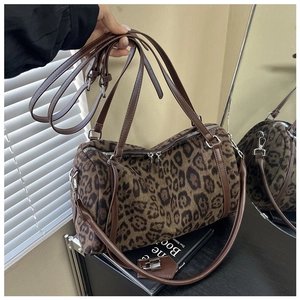Detail of leopard print tote bag with brown leather handles and silver metal hardware