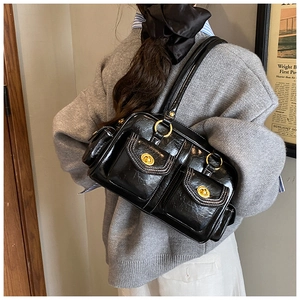 Detail of vintage black shoulder bag featuring gold twist-lock pockets and glossy leather