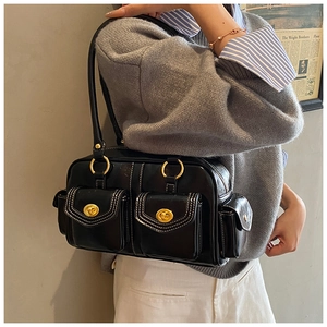 Detail of vintage black leather shoulder bag with gold turn-lock pockets and hardware