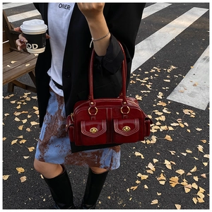 Detail view of burgundy vintage Boston bag with gold twist-lock front pockets