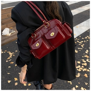 Detail of vintage burgundy pillow bag showing gold locks and white contrast stitching