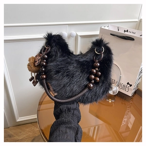 Detail of black faux fur handbag featuring wooden bead handle and leopard bow charm