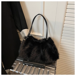 Close-up of black plush shoulder bag with long faux fur texture and slim strap