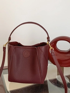 Burgundy bucket bag in lychee texture leather with gold hardware and logo