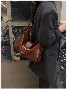 Détail du sac cabas en cuir ciré marron vintage avec une boucle métallique dorée élégante