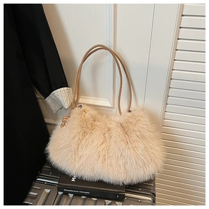 Detail of soft faux fur shoulder bag with leather straps on a vintage suitcase