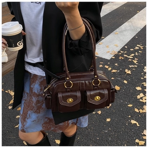 Detail of vintage dark brown pillow bag featuring polished leather and golden twist locks