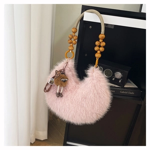 Pink fluffy faux fur crescent bag featuring unique wooden bead handle and monster charm