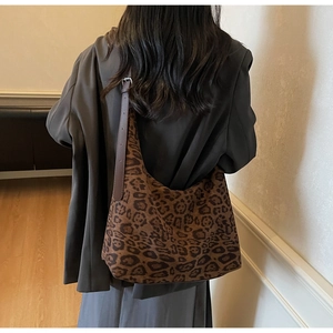 Detail showing side view of leopard print tote bag with adjustable leather strap