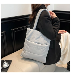 Detailed view of the quilted texture and wide strap of the padded grey tote bag