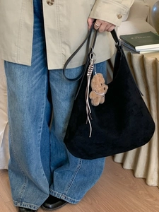 Retro black suede hobo shoulder bag with a teddy bear charm and fringe tassel detail