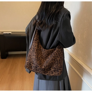Detail of large leopard print hobo bag showing texture and adjustable shoulder strap