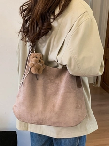 Vintage brown suede hobo tote bag with a cute plush bear charm for daily commuting