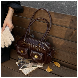 Detail of vintage coffee brown shoulder bag with gold twist locks and side pocket