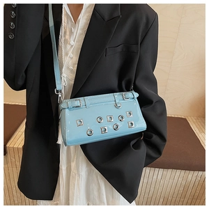 Detail view of light blue patent leather bag with silver metal eyelets and Y2K buckle design