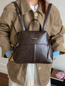 Deep brown faux leather minimalist backpack for women with top handle and metal logo