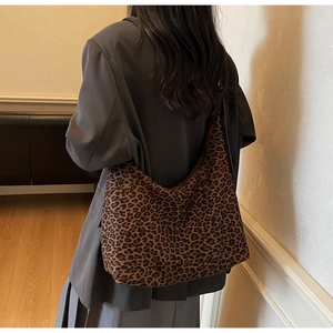 Detailed view of large leopard print tote bag worn on shoulder by a model